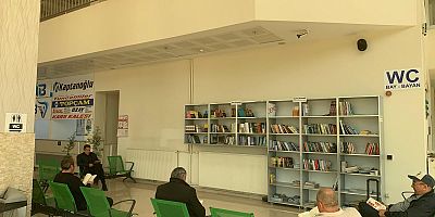 YOLCULAR OTOBÜSLERİNİ KİTAP OKUYARAK BEKLİYOR 